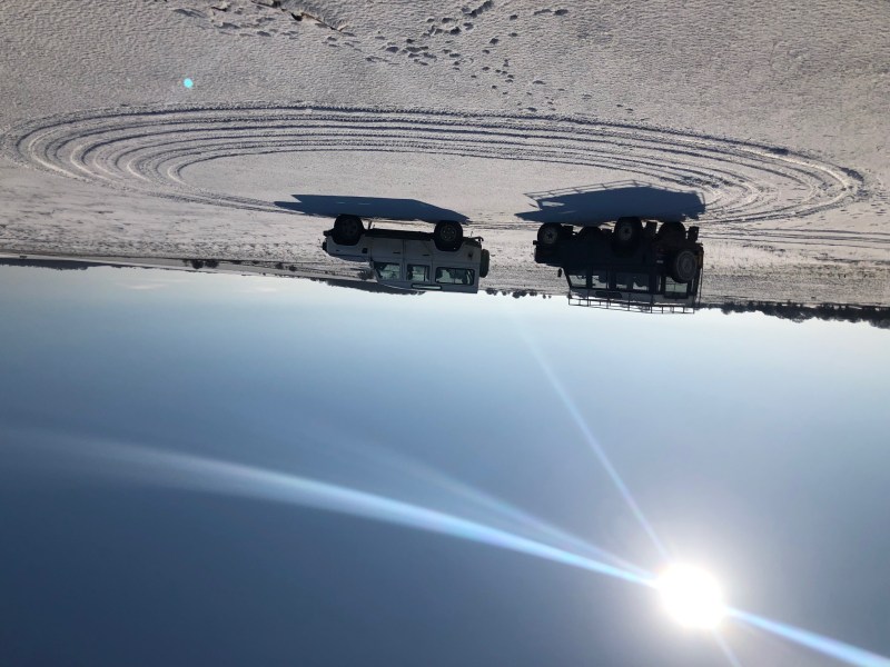 Two 4x4 Land Rovers on a snowy field